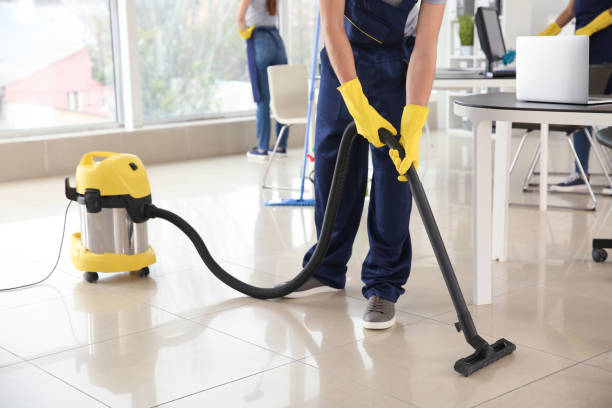 Professional cleaning staff performing vacuuming in a large office
